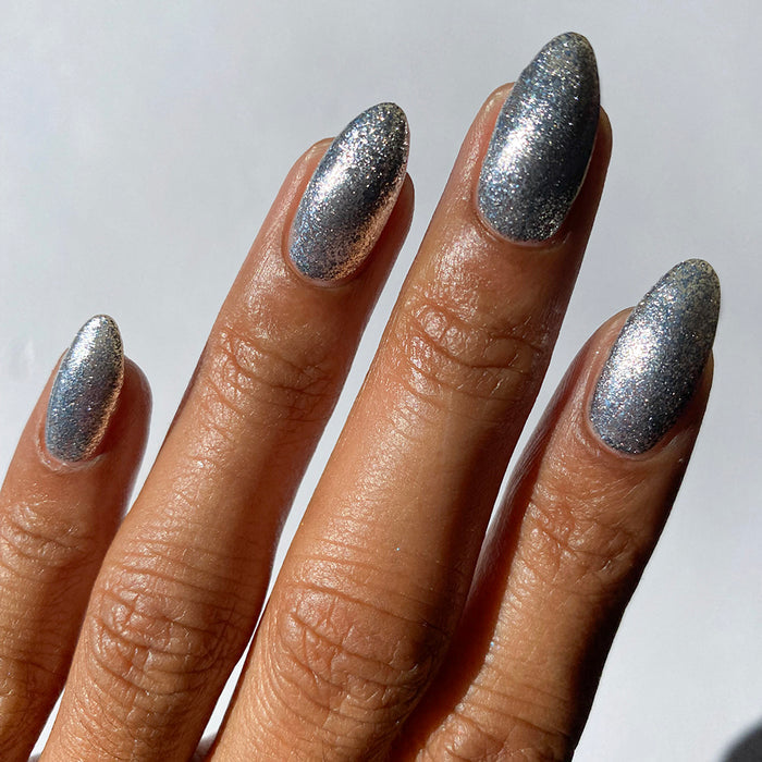 Close-up of nails painted with Broken Mirror Nail Lacquer on medium skin tone.