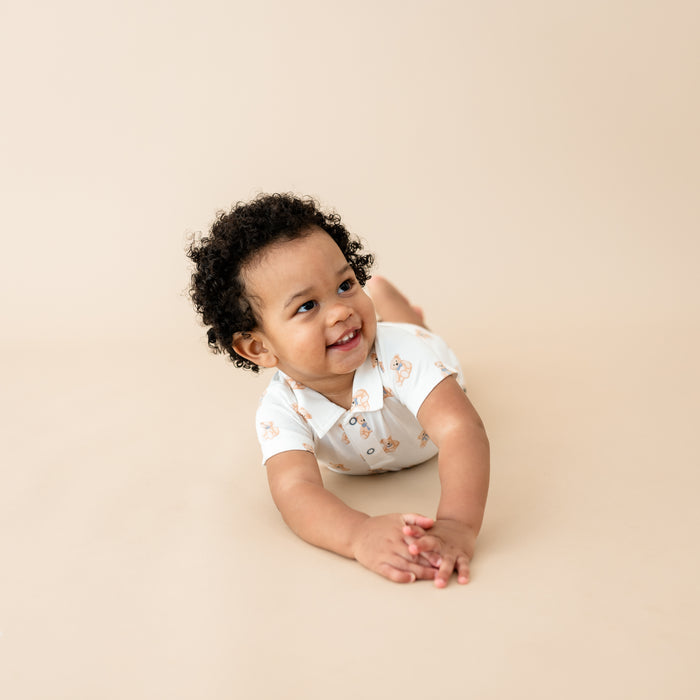 Toddler laying wearing Polo Shortall in Teddy Bear