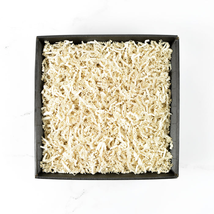 Square piece of textured white material in a black ribbed box on a white background