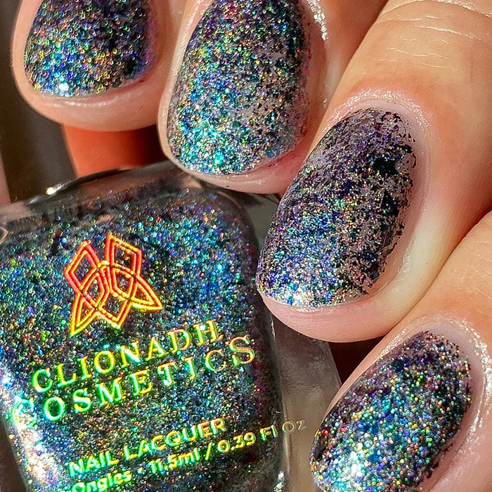 Close-up of nails painted with Step on a Crack Nail Lacquer on fair skin tone. Hand is holding polish bottle.