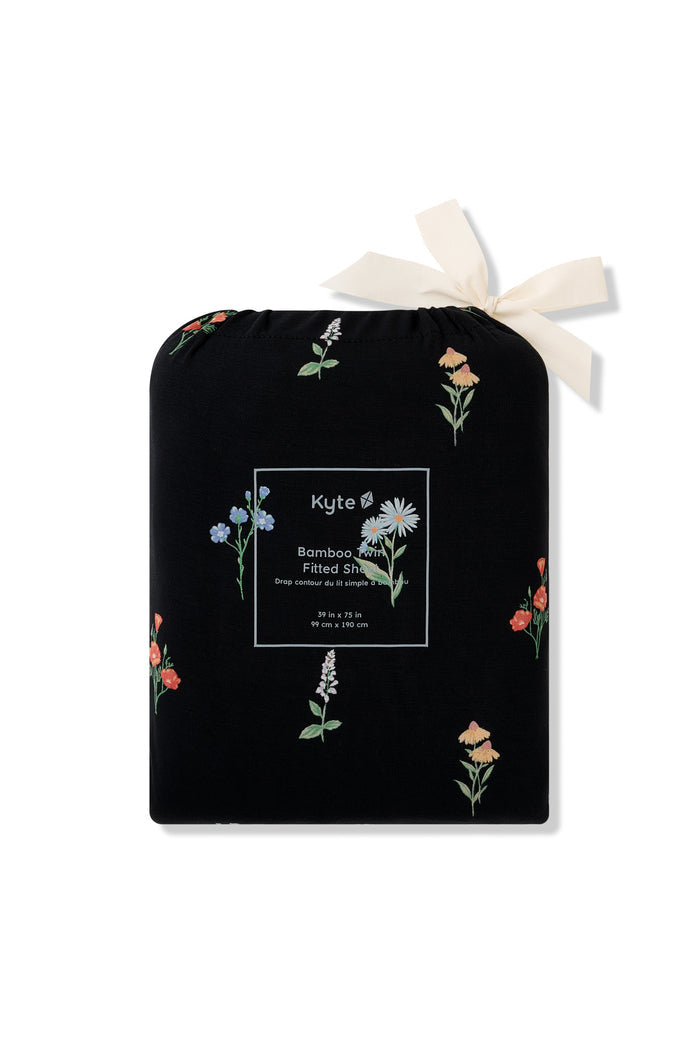 Twin Sheet in Wildflower print packed in a black bag with wildflower print on it on a white background