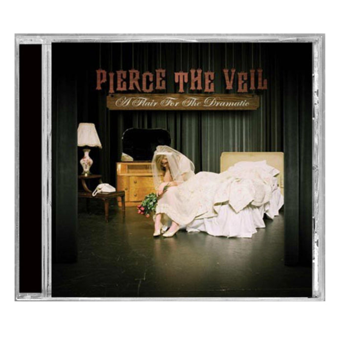 CD cover for Pierce The Veil’s A Flair For The Dramatic features a woman in a wedding dress on a bed with flowers, lamp, phone, and mirror under stage lights—a standout album from the band Pierce The Veil.