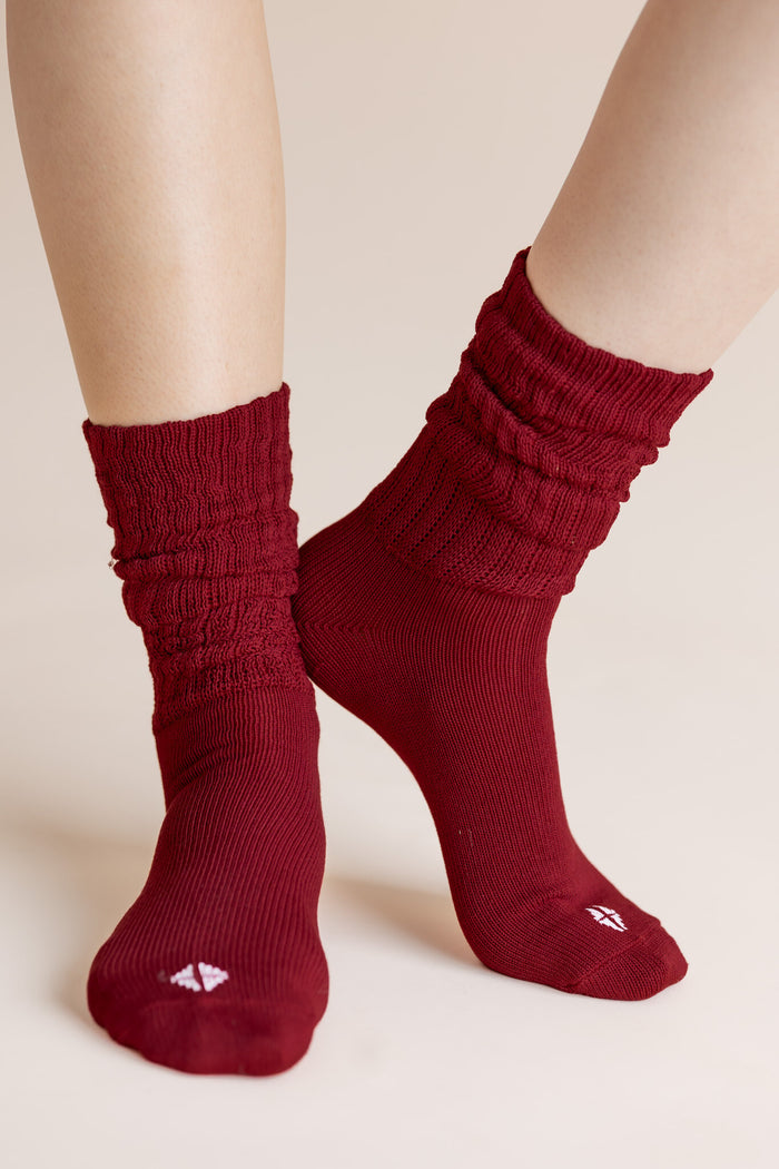 Model wearing Adult Scrunch Socks in Ruby shown on a beige background