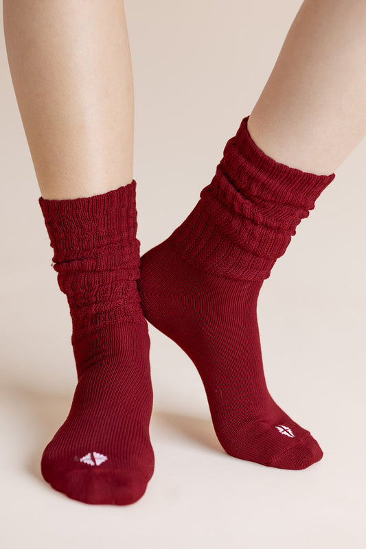 Model wearing Adult Scrunch Socks in Ruby shown on a beige background