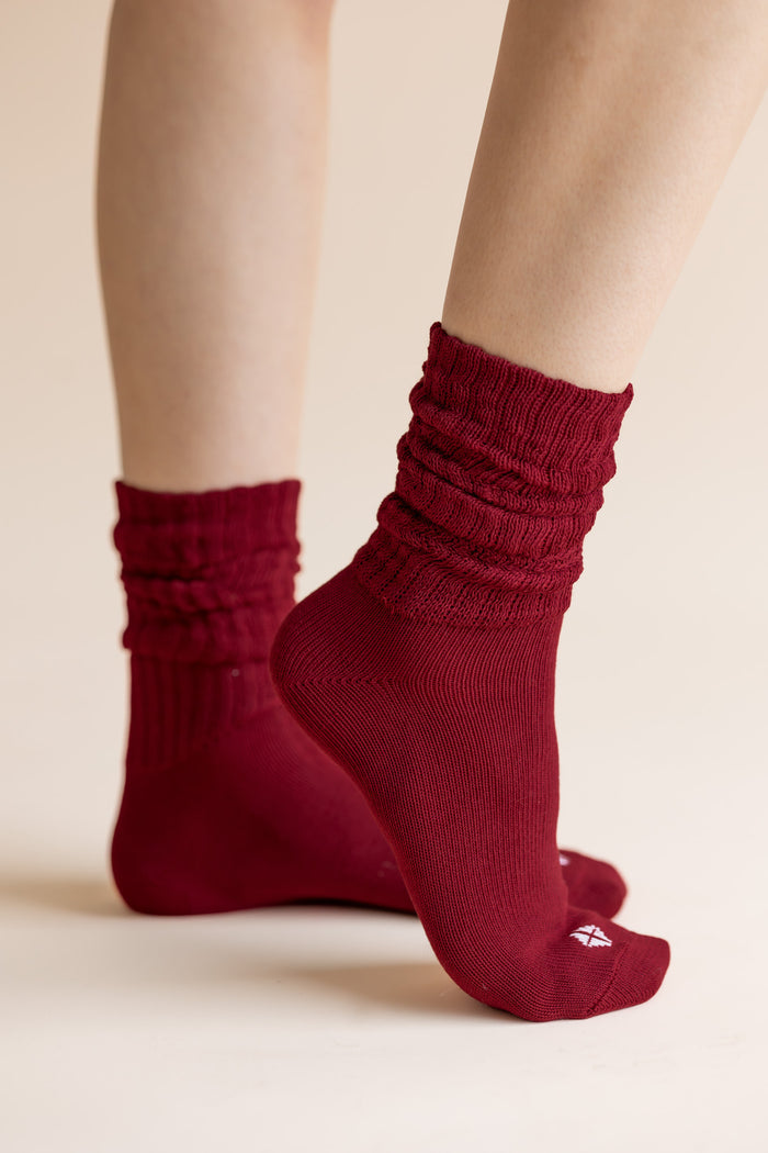 Model wearing Adult Scrunch Socks in Ruby on cream background