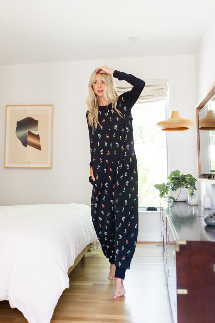 Model posing in Adult Sleeveless Sleep Bag Walker in Midnight Wildflower print in bedroom