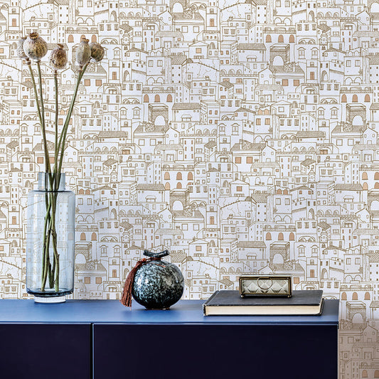 Amalfi WALLPAPER in metallic gold behind a long table with flowers and a vase.