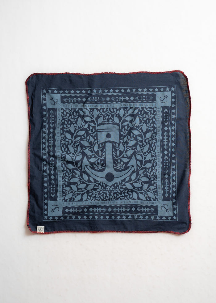 Navy bandana with anchor and leaf design, bordered by stars and arrows. Red stitching edges. Iron & Resin branding visible.