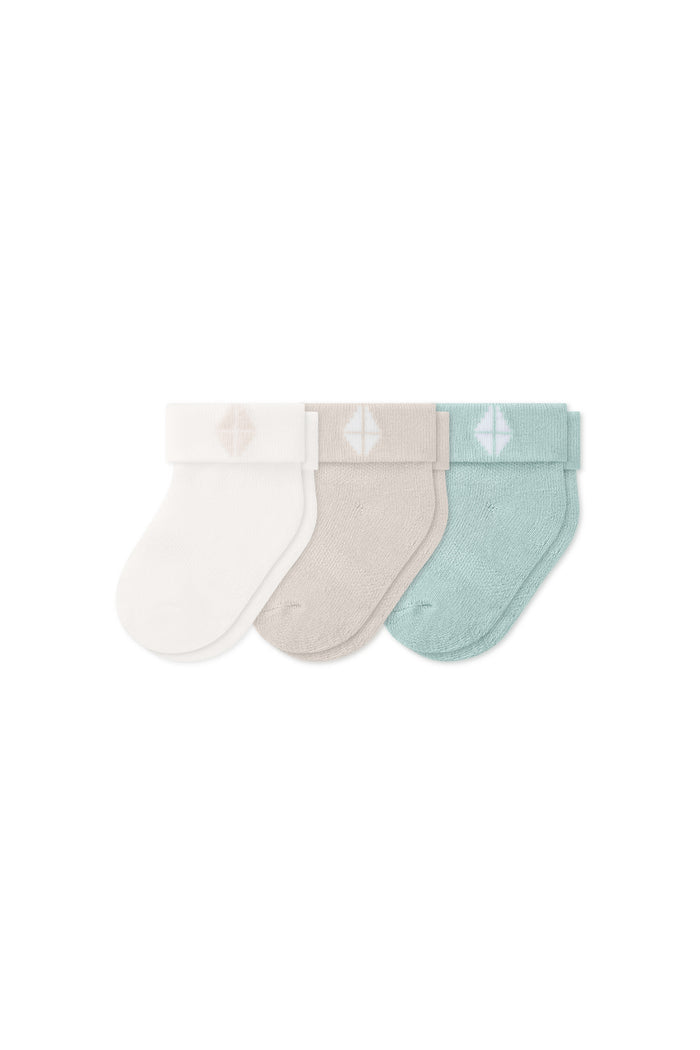 Three socks in Cloud, Oat, and Sage laying flat on a white background.