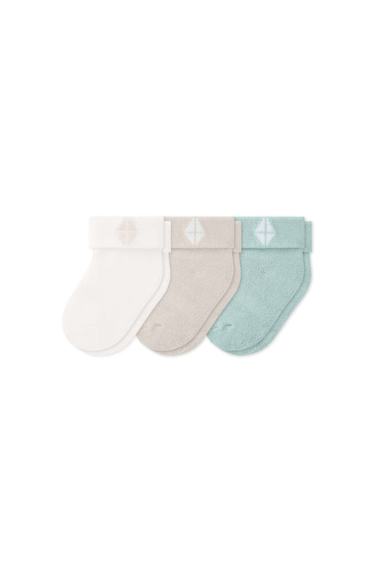 Three socks in Cloud, Oat, and Sage laying flat on a white background.