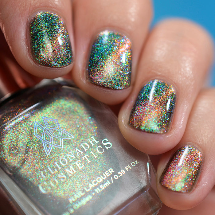 Close-up of nails painted with Baeocystin Nail Lacquer on fair skin tone. Hand is holding polish bottle.