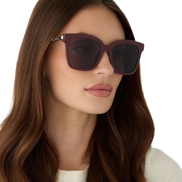 on model - female wearing diff eyewear bella oversized square sunglasses with a rugby red acetate and gold metal frame with grey lenses angled view