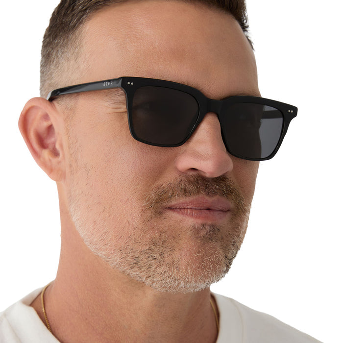 on model - male wearing Billie sunglasses with black frame and grey polarized lens-detailed view