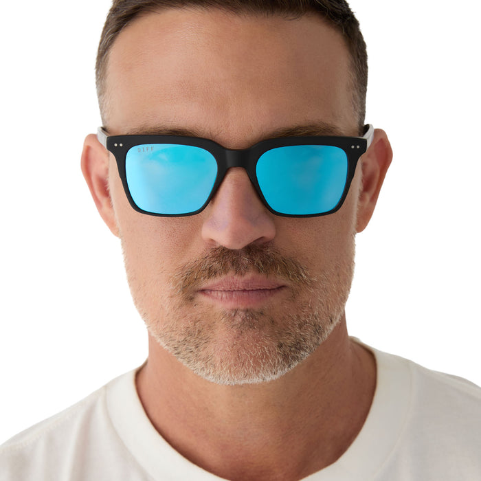 on model - male wearing Billie sunglasses with matte black frame and blue mirror lens-front view