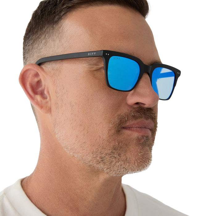 on model - male wearing Billie sunglasses with matte black frame and blue mirror lens detailed view
