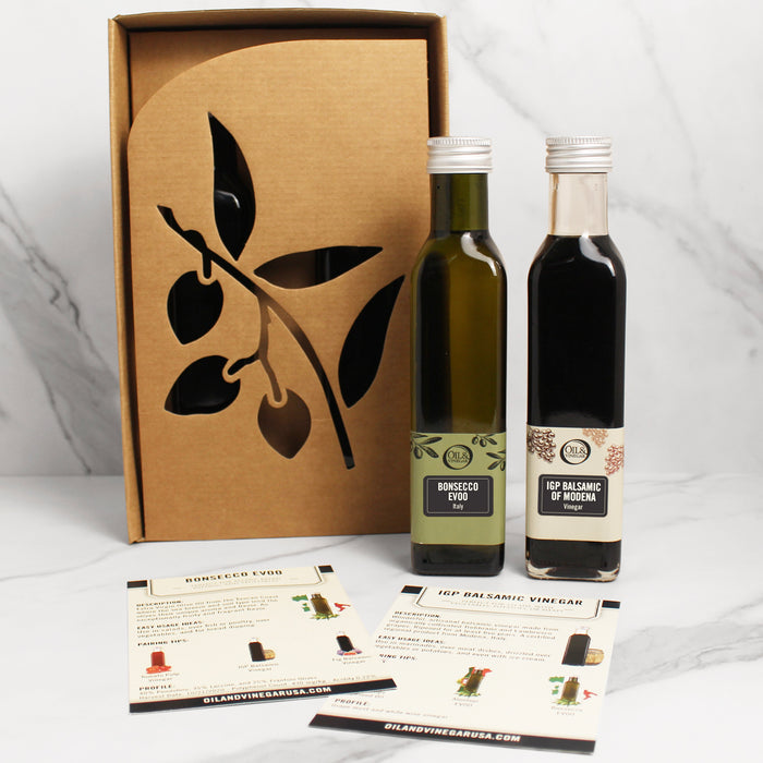 Two bottles, one labeled Bonsecco EVOO and the other Balsamic IGP Modena, next to a presentation box with leaf motifs.