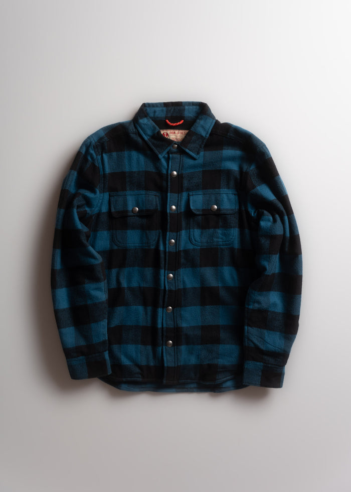 Blue and black plaid flannel shirt with snap buttons, laid flat on a white background, showcasing its casual style.