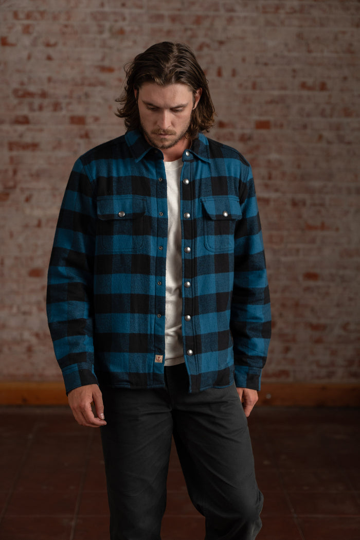 Close-up of a person in a white shirt and blue jeans, highlighting the denim texture and casual style against a blurred background.