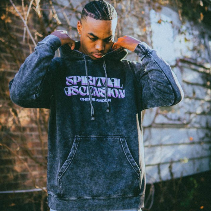 Someone wearing the Greyish Black hoodie with "Spiritual Ascension" written in big pinkand white letters on the front. Below "spiritual ascension" reads "Cherie Amour" in smaller purple letters