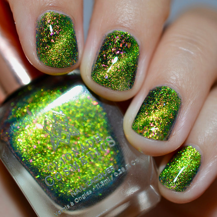 Close-up of nails painted with Conocybe Nail Lacquer on fair skin tone. Hand is holding polish bottle.