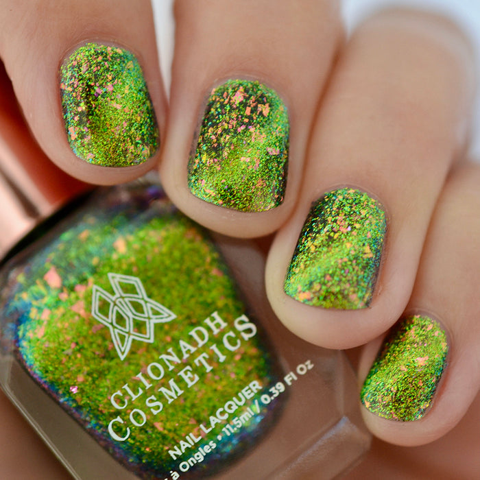Close-up of nails painted with Conocybe Nail Lacquer on fair skin tone. Hand is holding polish bottle.