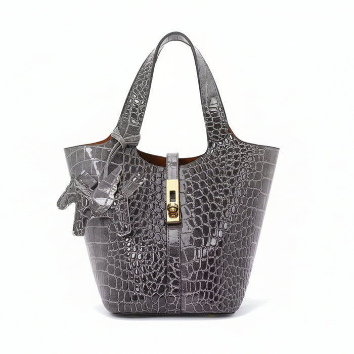 Gray crocodile-embossed handbag with gold clasp on a white background