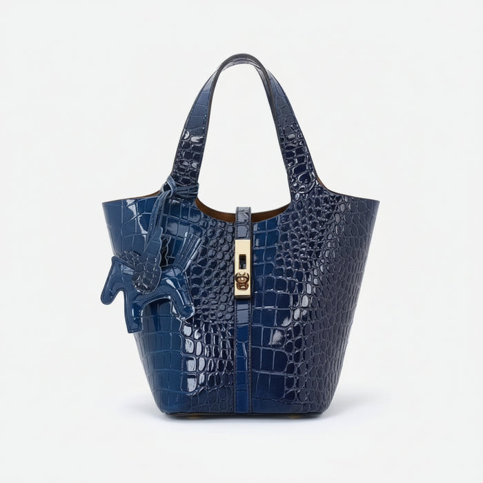 Blue crocodile-patterned handbag with a gold zipper on a white background