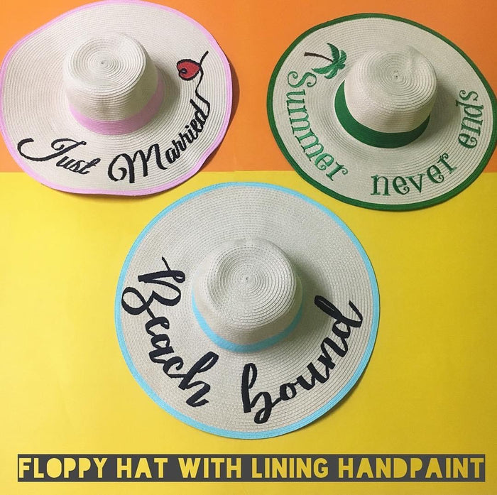 Custom hand-painted floppy hat collection with unique lettering and colorful trim by Travellers Hat Boutique