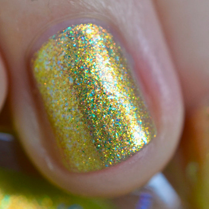 Close-up of one nail painted with Dais Nail Lacquer on fair skin tone. Emphasizes golden and green shimmer particles.