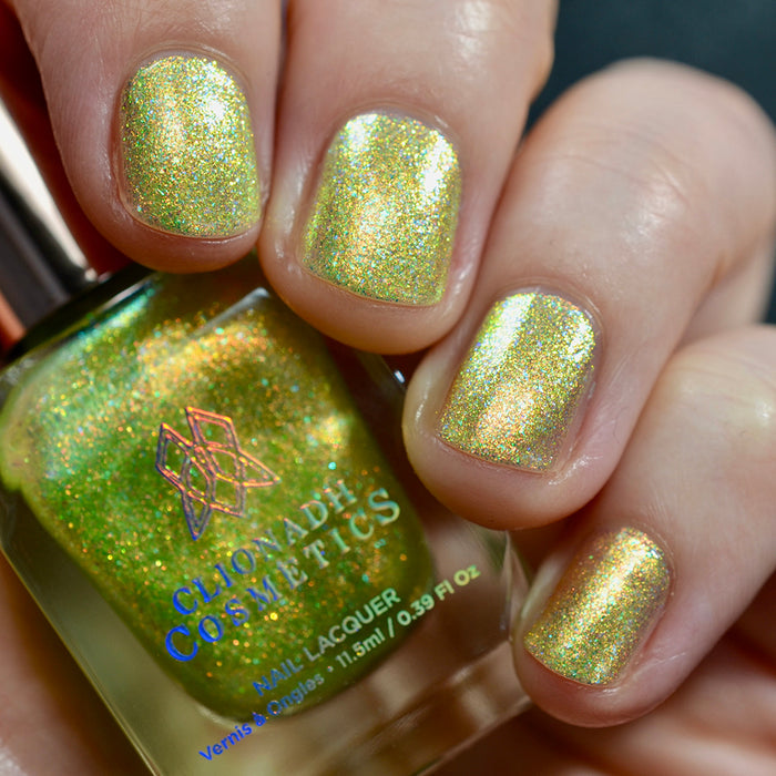 Close-up of nails painted with Dais Nail Lacquer on fair skin tone. Hand is holding polish bottle.