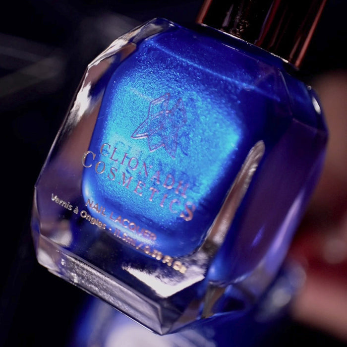 Angled, close-up of Don't Open Inside! Nail Lacquer bottle, on a blurred background.