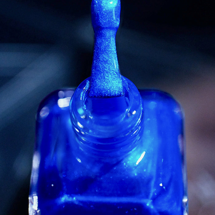 Close-up of nail polish bottle and brush showing product Don't Open Inside! Nail Lacquer, on a blurred background.
