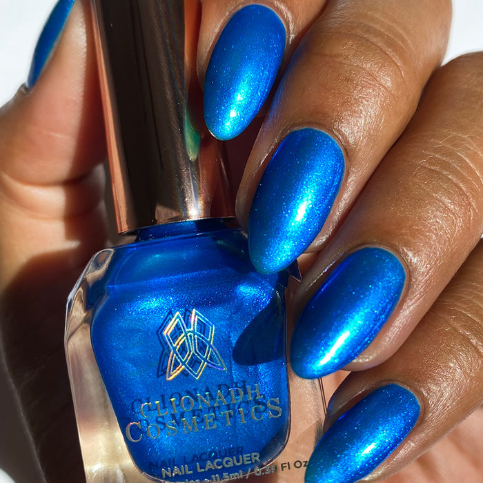Close-up of nails painted with Don't Open Inside! Nail Lacquer on medium skin tone. Hand is holding polish bottle.