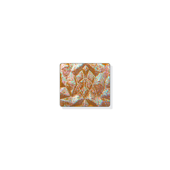 A single multichrome eyeshadow in colour Exothermic on a white background. A multidimensional shadow with a tan base with medium sized particles that shift pink-peach-chartreuse with hints of aqua glitter