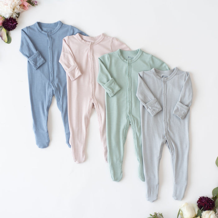 Flay lay of  Kyte Baby Footies in Slate, Blush, Sage and Fog