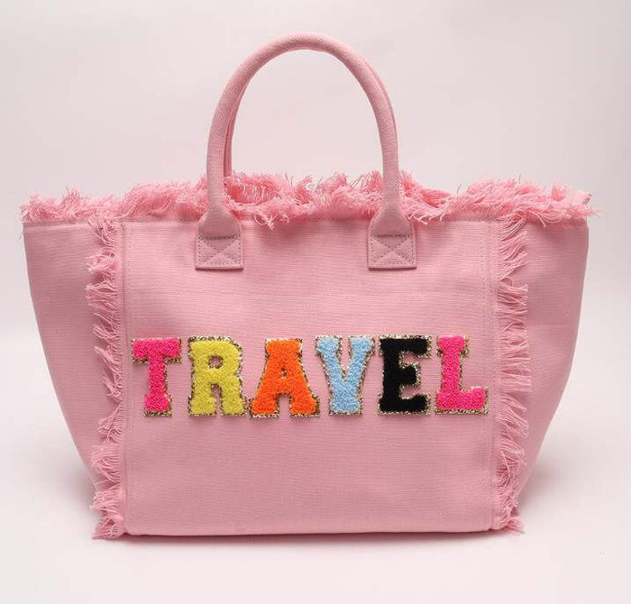Pink personalized canvas tote with fringe and colorful travel letters by Travellers Hat Boutique