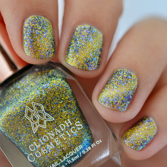 Close-up of nails painted with Galerina Nail Lacquer on fair skin tone. Hand is holding polish bottle.