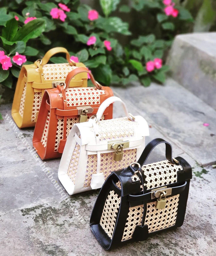 Collection of genuine leather solihiya bags in black white brown and mustard colors displayed outdoors