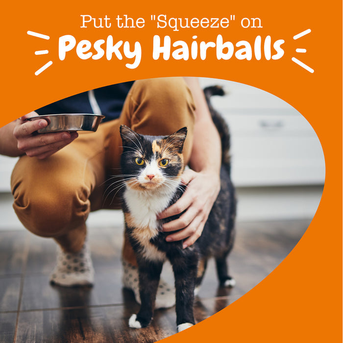 Person holding a calico and white cat while squeezing mousse from a tube onto its fur.