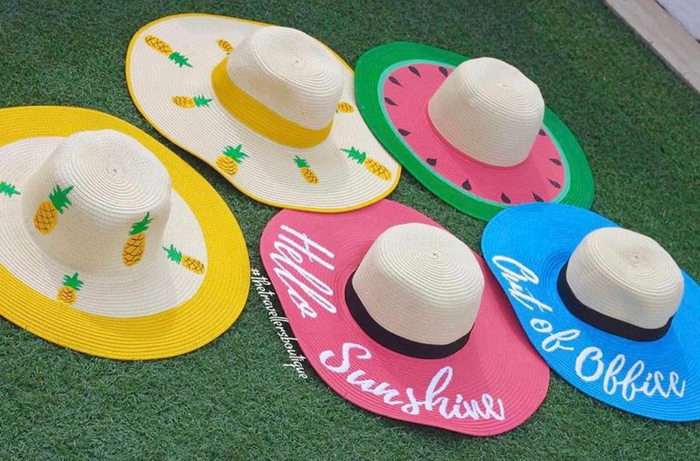 Customizable hand-painted straw hat collection featuring pineapples and watermelon designs from Travellers Hat Boutique