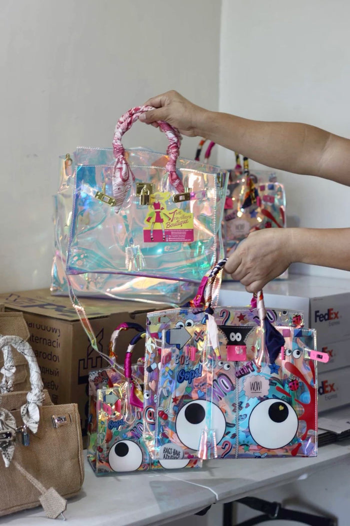 Traveller Hat Boutique holographic clear tote bag with pink handles and colorful cartoon designs