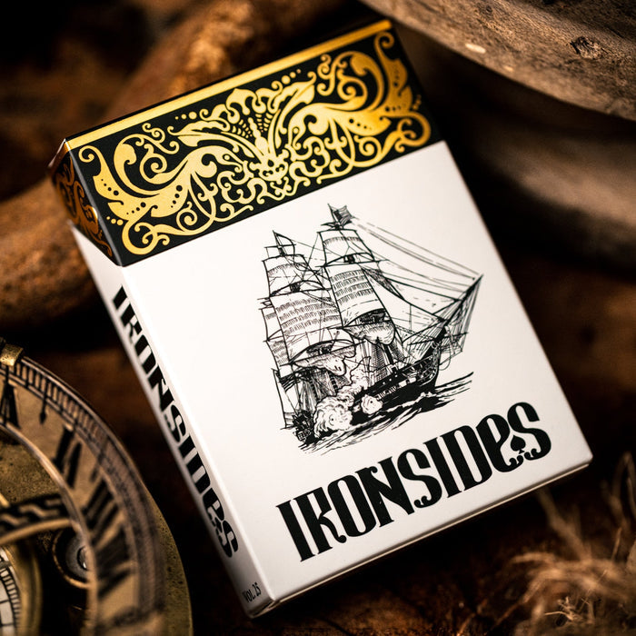 Playing card box with 'Ironsides' branding and ship illustration, surrounded by wooden elements and a compass.