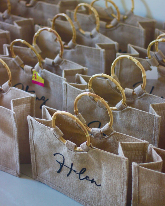 Natural jute totes with bamboo handles from Travellers Hat Boutique featuring personalized name design