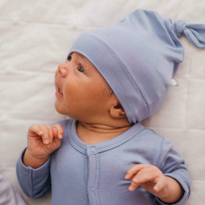 Infant wearing a wearing a Kyte Baby Knotted Cap and Footie in Slate