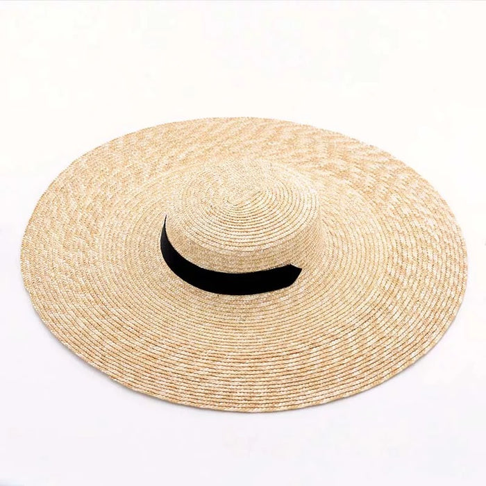 Large wheat straw hat with wide brim and black band from Travellers Hat Boutique