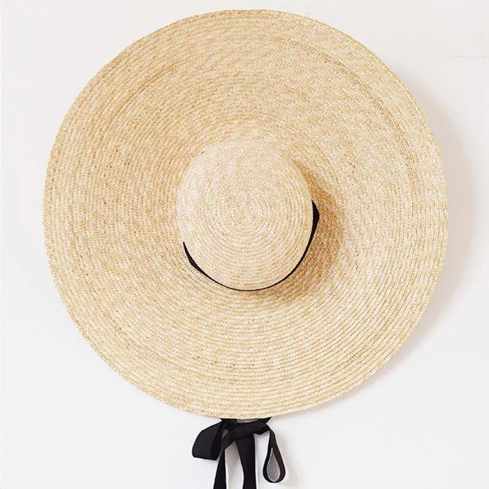 Large wheat straw hat with wide brim and black tie detail from Travellers Hat Boutique