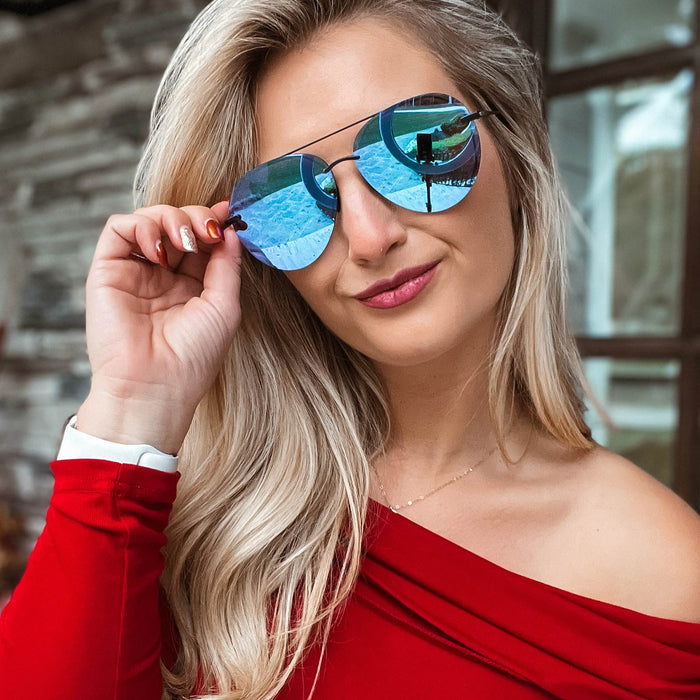 UGC - lifestyle - ambermiller9 wearing Lenox sunglasses with matte black frames and purple mirror lens holding them