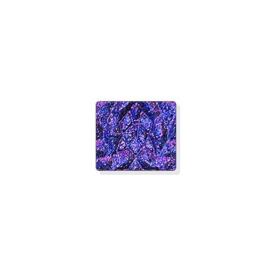 A single multichrome eyeshadow in colour Liquidus on a white background. A black base with medium sized particles that shift ultraviolet-pink-orange-grungy yellow with hints of red and cobalt sparkle.
