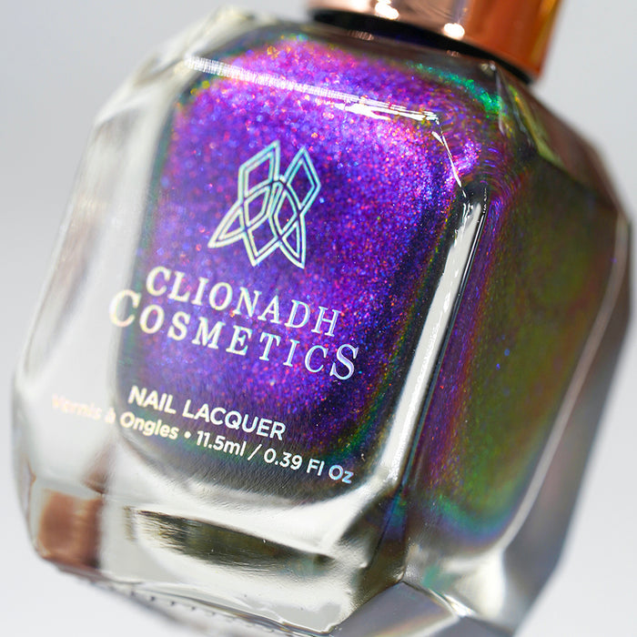 Angled, close-up of Liquidus Nail Lacquer bottle on a black background.