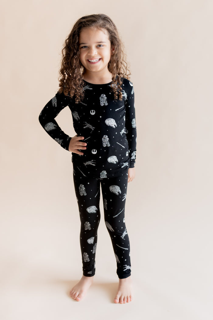 Girl wearing Long Sleeve Pajamas in STAR WARS™ print on a cream background
